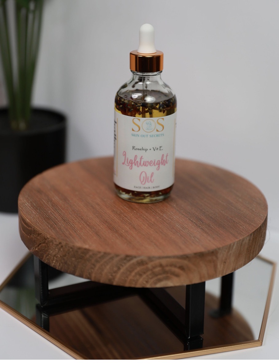 Skin Out Secrets Lightweight Oil styled on a wooden riser
